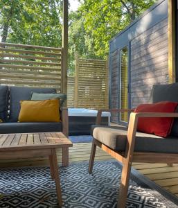 un patio con 2 sofás, una mesa y un banco en Chant des Oiseaux ***, en Royan