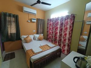 a small room with a bed and curtains in it at Trendz service apartments in Chennai