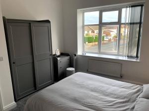 a bedroom with a bed and a window at New large 2 bedroom apartment with private parking 