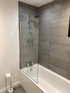 a bathroom with a shower and a bath tub at New large 2 bedroom apartment with private parking 
