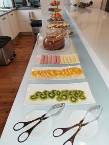 a buffet with several different types of food with scissors at R3 Service - Five Senses in Coimbra in Coimbra