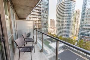 two chairs on a balcony with a view of a city at Gorgeous Condo in Downtown Near CN Tower in Toronto
