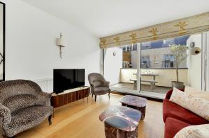 sala de estar con sofá y TV en 3 bdrm Notting Hill Mews house - 2 balconies en Londres