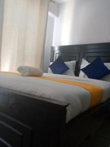 - une chambre avec un grand lit et des oreillers bleus dans l'établissement Rew Apartment, à Nairobi