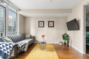 a living room with a couch and a tv at Gorgeous Condo in Downtown Near CN Tower in Toronto