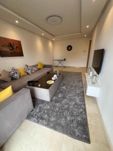 ein Wohnzimmer mit einem Sofa und einem Tisch in der Unterkunft Prestigia murcia 4 in Rabat