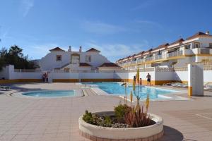 Un patio con piscina y algunos edificios. en Casa Kiko Sol, en Caleta de Fuste