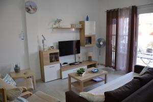 Una sala de estar con un sofá y un televisor. en Casa Kiko Sol, en Caleta de Fuste