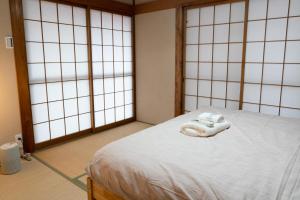大阪市にあるGC01/生活してもOKな親切な部屋 /3 部屋/最大 6人入居/大阪城/3 ライン駅徒歩7分/清潔の白いタオルが付いたベッドが備わる客室です。