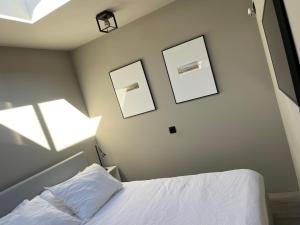 een slaapkamer met 2 foto's aan de muur en een bed bij Modern guest house. in Bergen