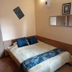 a bed in a room with blue pillows on it at "Vanilla" Pokoje i Apartamenty Nad Brzegiem Jeziora in Okuninka