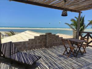 a table and chairs on a deck with the beach at Pousada Por do Sol in Barra Nova