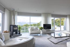 a living room with white furniture and a large window at Fern View House over Loch Ness in Inverness