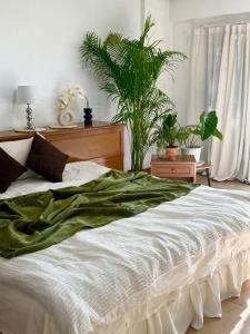 um quarto com uma cama grande com plantas em Sandra’s sweet house em Chiang Mai