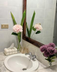 um lavatório de casa de banho com flores cor-de-rosa no espelho em Sandra’s sweet house em Chiang Mai mais 4 fotografias