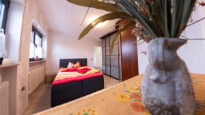 ein Schlafzimmer mit einem Bett und einer Vase auf einem Tisch in der Unterkunft may-homestay-saar in Neunkirchen