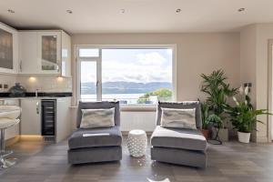 ein Wohnzimmer mit 2 Stühlen und eine Küche in der Unterkunft Fern View House over Loch Ness in Inverness