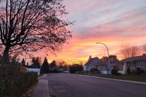 an empty street in a residential neighborhood with a sunset at Guest Suite in Saint Hubert, bus to REM and Metro in Longueuil