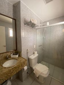 uma casa de banho com um WC, um lavatório e um chuveiro em Pousada Tropical Ilhas em Aquiraz