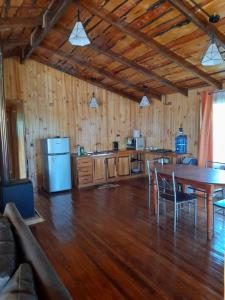 eine Küche mit einem Tisch und eine Küche mit Holzböden in der Unterkunft Compu alto in Quellón
