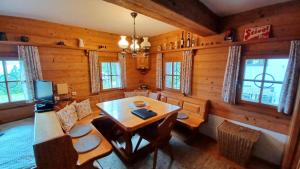 uma sala de jantar com uma mesa e algumas janelas em Ferienhütte Panoramablick 