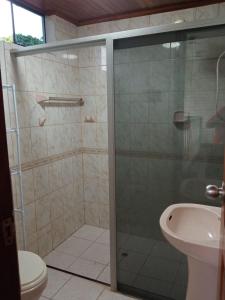 a bathroom with a shower with a toilet and a sink at DouchkaHouse in Puerto Maldonado
