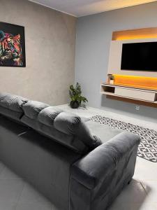 ein Wohnzimmer mit einem Sofa und einem Flachbild-TV in der Unterkunft Confortável APTO em Boa Vista. in Boa Vista