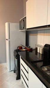 a kitchen with a black counter top and a refrigerator at Confortável APTO em Boa Vista. in Boa Vista