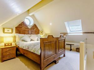 een slaapkamer met een groot houten bed en een raam bij 1 bed in Stow-on-the-Wold 52145 in Naunton