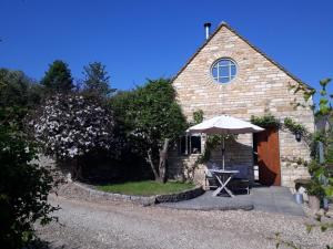 a small stone building with an umbrella and a table at 1 bed in Stow-on-the-Wold 52145 in Naunton