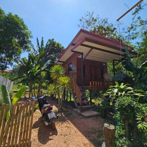 ein kleines Haus mit einem Motorrad davor geparkt in der Unterkunft Easy Life Country House in Ko Lanta