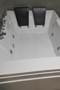 a white bath tub with two speakers on it at Estúdio com Hidromassagem em casa com Pisicna e Churrsqueira in Santar