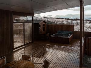 a deck with a hot tub and a table and chairs at Golden Circle Villa - Hot Tub & Sauna in Fludir
