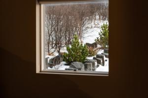 a window with a christmas tree in the snow at Golden Circle Villa - Hot Tub & Sauna in Fludir