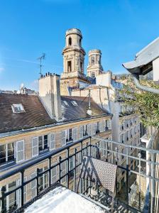 einen Balkon mit einer Bank und einem Gebäude in der Unterkunft Saint Sulpice Towers in Paris