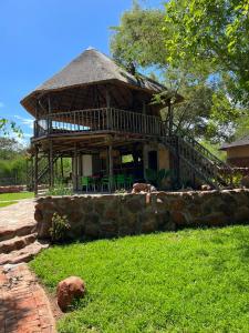 a large building with a porch and a stone wall at Kolobeng Valley in Ranku