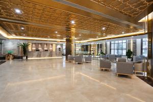 a lobby with a waiting area with chairs and tables at Grand Pailin Casino & Resort 