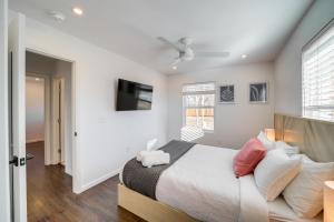 1 dormitorio con 1 cama y TV en la pared en Charming Tulsa Vacation Rental with Patio!, en Tulsa