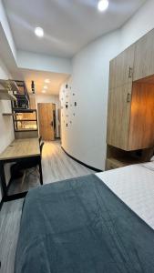 a room with a bed and a desk and a wall at Living para 2 personas, Apartaestudio - Santa Bárbara, Bogotá in Bogotá