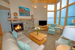 a living room with a couch and a fireplace at Surfside on Lake Superior in Tofte