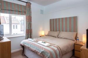 Schlafzimmer mit einem Bett und einem Fenster in der Unterkunft Sunny Queens Park Home - Garden & Private Parking in Brighton & Hove