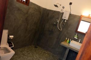 a bathroom with a toilet and a sink and a shower at Lake & Ocean Villa ahangama in Elagawagoda +36 photos