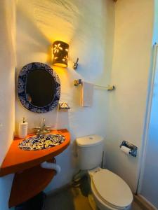 a bathroom with a toilet and a sink at Habitacion privada con pisicina y cocina compartida in Sayulita