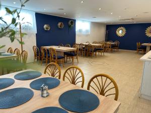 un restaurante con mesas y sillas y una pared azul en Danelis Hotel, en Edelény