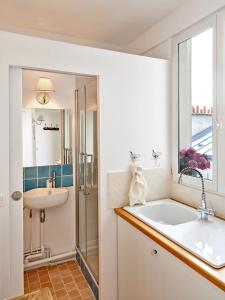 ein Badezimmer mit einer großen Badewanne und einem Waschbecken in der Unterkunft Saint Sulpice Towers in Paris