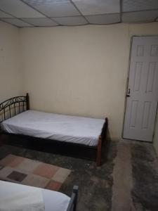 1 dormitorio con 1 cama en una habitación con puerta en Hostal Buena Esperanza El Copé de La Pintada, en El Copé