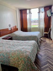 a hotel room with two beds and a window at América inn in Puno