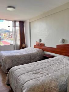 a hotel room with two beds and a window at América inn in Puno