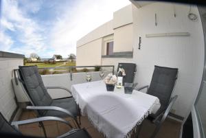 una mesa con un mantel blanco en el balcón en Tannenburg 208 - App Strandoase, en Grömitz