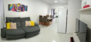 uma sala de estar com um sofá e uma pintura na parede em Casa aconchego da Camila em Foz do Iguaçu